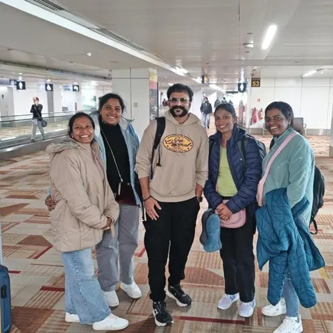 Five travellers in winter jackets inside an airport terminal
