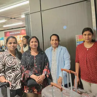 Four women with suitcases ready to travel