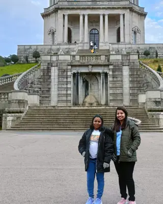 Two women in front of a monument abroad