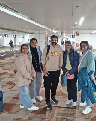 Five travellers in winter jackets inside an airport terminal