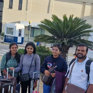 Five travellers with bags and luggage outdoors